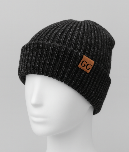 Black knit beanie with a brown logo patch on a mannequin head against a gray background