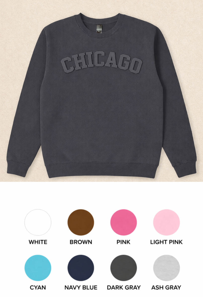 Dark gray sweatshirt with 'Chicago' text on a beige background, color swatches below.