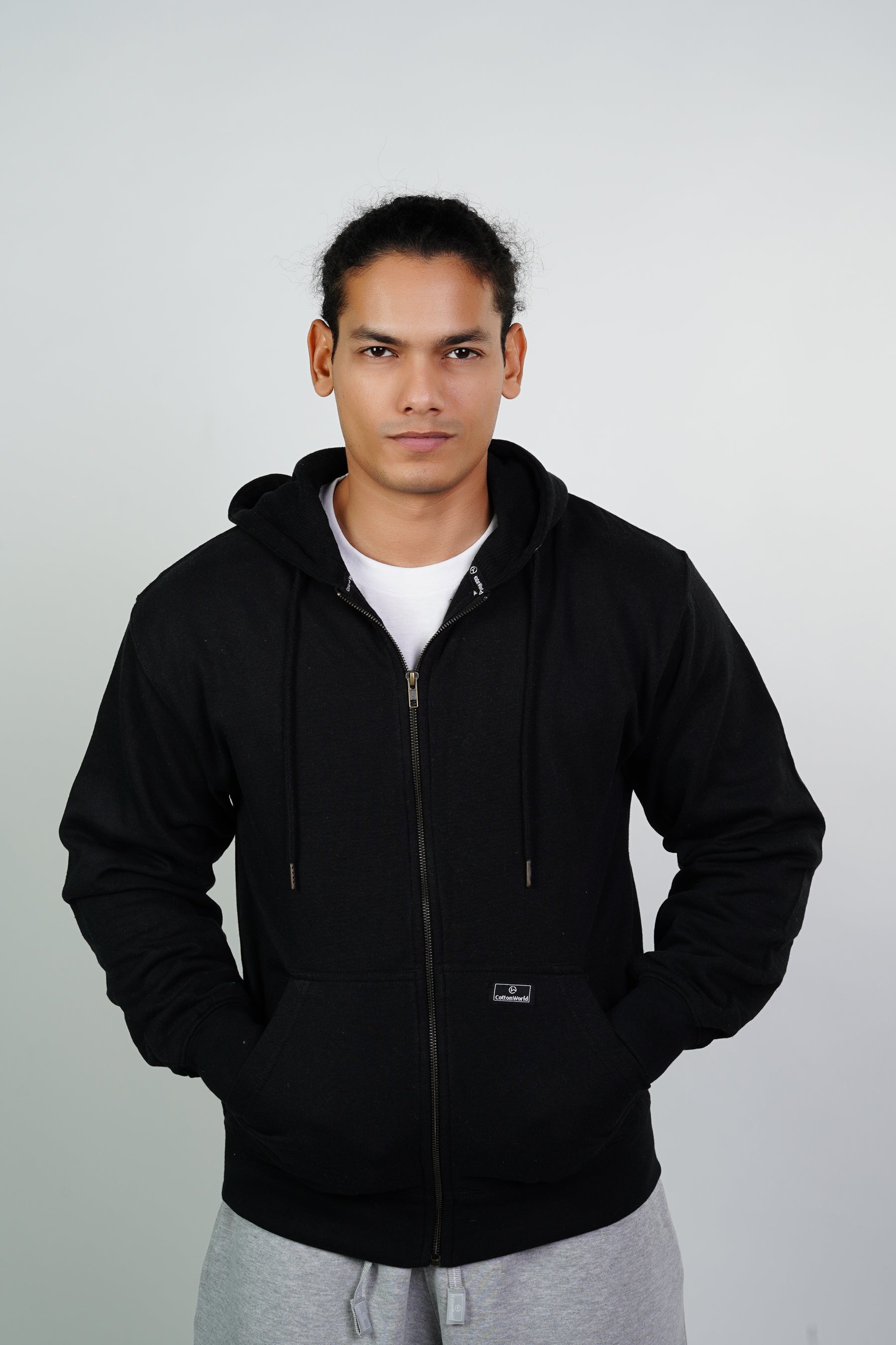 A person wearing a black thermal lined zipper hoodie with hood up, standing against a neutral background.